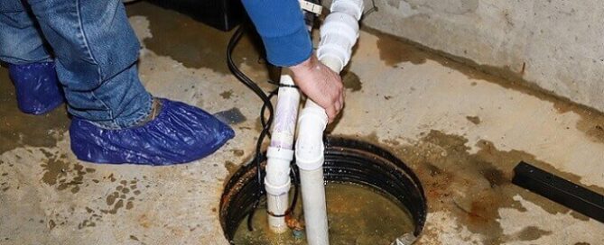 a Saanch plumber inspecting a sump pump for Saanich plumbing services