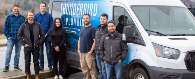 Our Plumbers stand in front of a service truck, ready to head to a local project site.